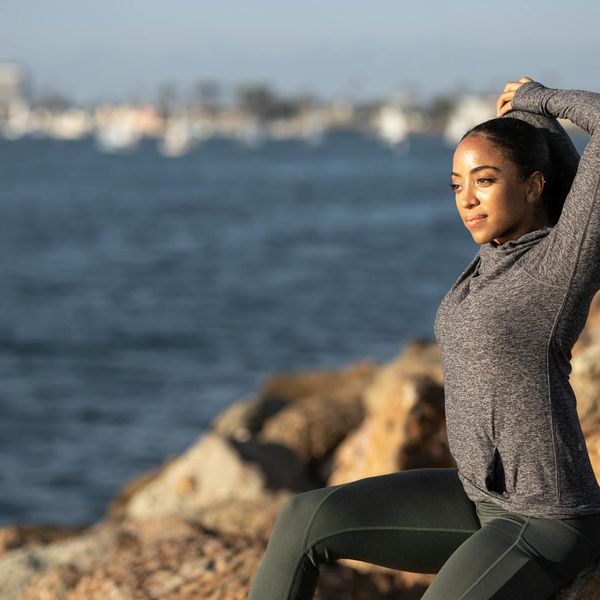 Person stretching gently outdoors during a sunny morning, feeling peaceful.